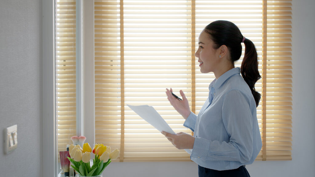 Young female leader, happy standing smile look at in front of mirror pep talk for sale pitch hold paper document script public speak skill for job career self improve.