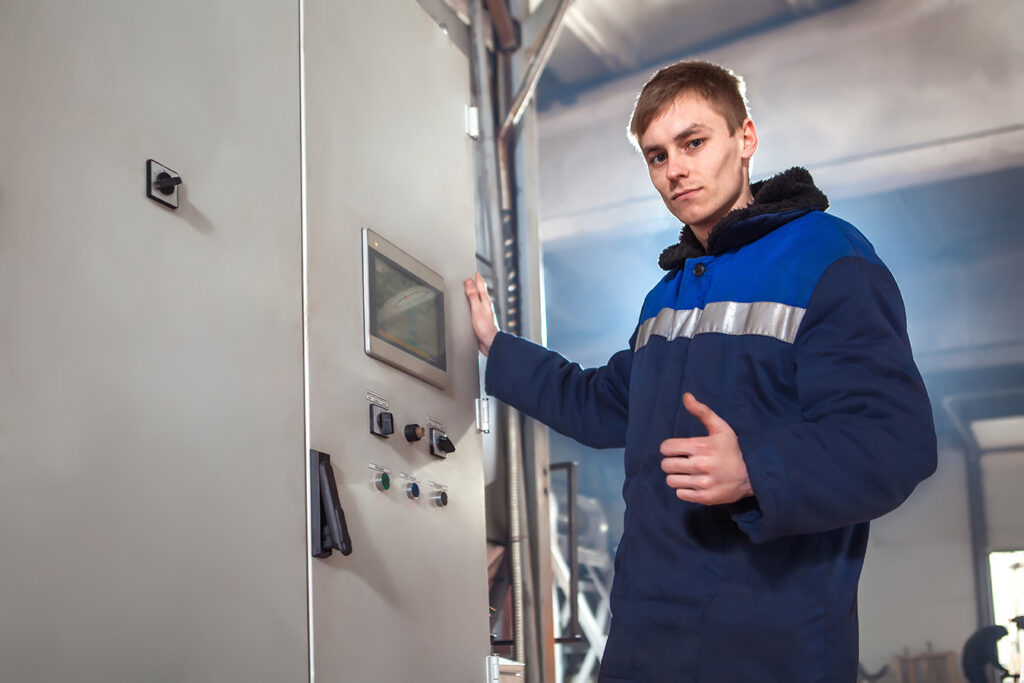 Professional industrial engineer adjusting modern machine settings.